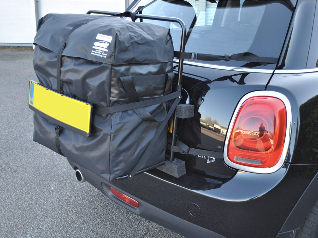 black mini countryman with a hatch-bag roof box fitted in a car park photographed close