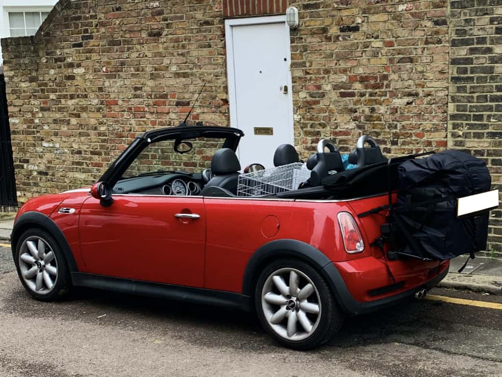 red mini r52 convertible with a hatch-bag luggage rack fitted next to a wall
