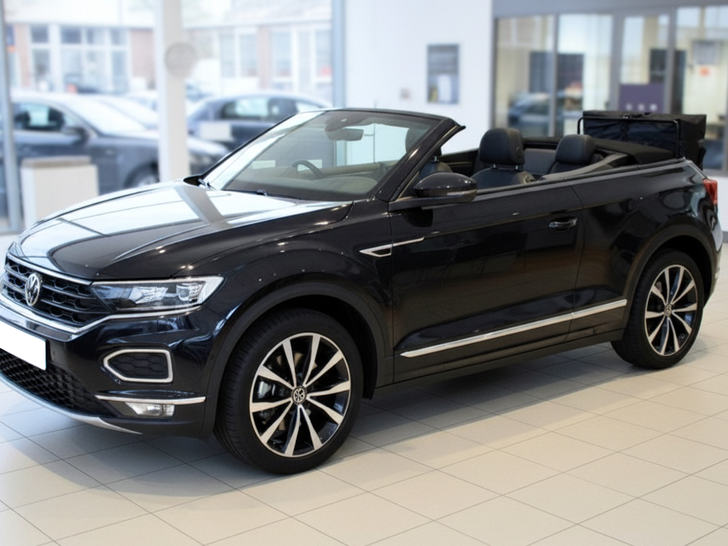 Black Volkswagen VW T-Roc Convertible with a hatch-bag luggage carrier rack fitted to then rear, photographed in a VW showroom